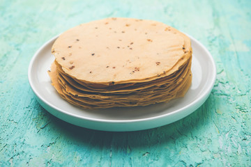 Gujarati papad or papadum in raw dried form with roasted cone, roll and flat variation