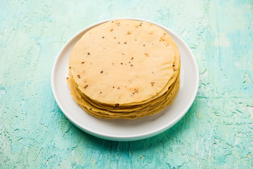 Gujarati papad or papadum in raw dried form with roasted cone, roll and flat variation