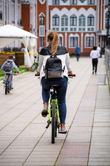 People ride bicycles along the embankment. Cyclists ride around the city.