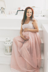 Portrait of a beautiful pregnant woman in the room