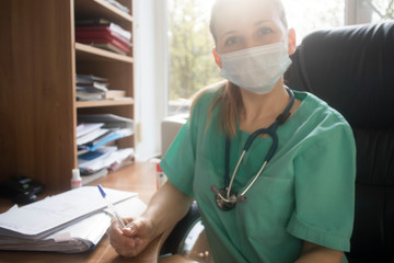 Doctor woman at work. Female physician filling up medical form while sitting at the desk in clinic or hospital. Medicine and healthcare concept for advertising
