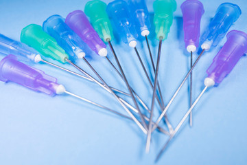 needles of the syringes on a blue background, the concept of medicine