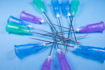 needles of the syringes on a blue background, the concept of medicine