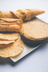 Gujarati papad or papadum in raw dried form with roasted cone, roll and flat variation