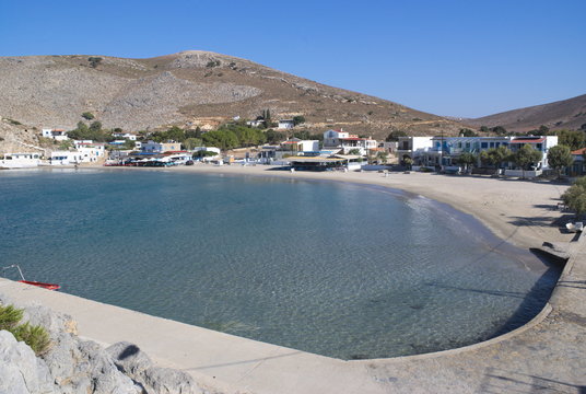 Greece, the island of Pserimos in the Dodecanese.  The harbor beach at Avalakia, before the day trip boats arrive.  The view from the jetty.