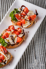 Bruschetta with tomatoes, lettuce, camambert, balsamic vinegar