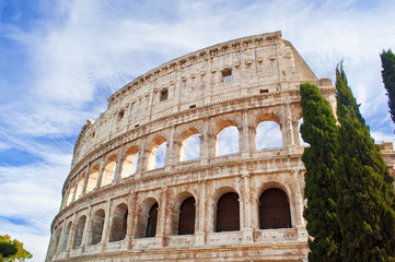 View of the top of amphitheater of Colosseum against blue sky with wispy clouds