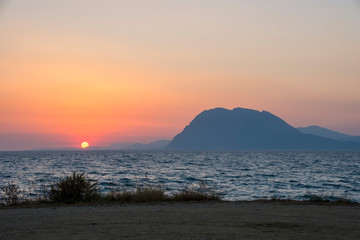 Beautiful summer sunset near sea and mountain background