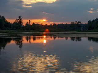 Naklejka premium beautiful sun set on calm lake, red sun, calm lake, quiet evening, Latvia
