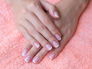 Closeup french manicure in a beauty salon. Woman hand care. Beauty woman nails