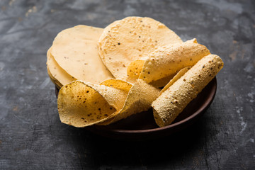 Gujarati papad or papadum in raw dried form with roasted cone, roll and flat variation