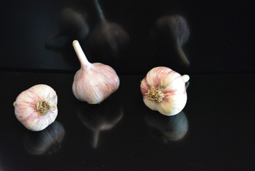 Fresh vegetables, three heads of a calf with a reflection on a black glossy surface with repeated...