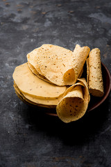 Gujarati papad or papadum in raw dried form with roasted cone, roll and flat variation