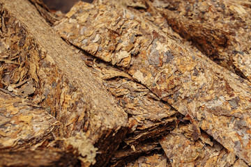 Photo of cutted dry tobacco leaves in cloth sack for cigarette industry.