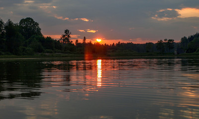Fototapeta premium beautiful sun set on calm lake, red sun, calm lake, quiet evening, Latvia