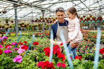 Happy father and daughter at plant nursery.