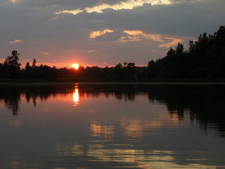 Obraz premium beautiful sun set on calm lake, red sun, calm lake, quiet evening, Latvia