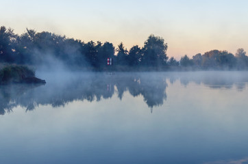 Obraz na płótnie Canvas Morning landscape with fog over the lake