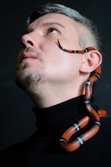 photo portrait of a man with a sinaloy milk serpent dark background