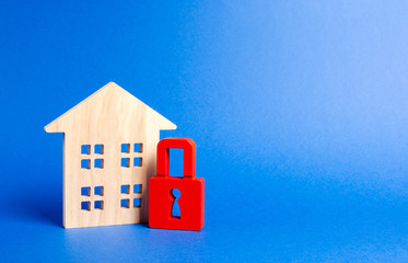 Fototapeta na wymiar Wooden house and a red padlock. Security and safety. Unavailable and expensive real estate. house Insurance Confiscation for debts. alarm system. seizure of property. Protection of property rights.