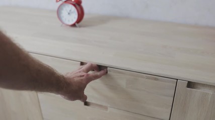 Oak furniture in a classic style - a man opens a drawer