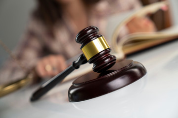 Female attorney in the legal office. Gavel and legal code on the white table.