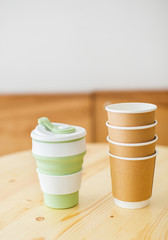 Reusable coffee mug and plastic cups for coffee to go.