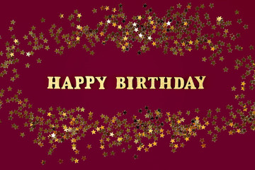 Text Happy birthday laid out of gold letters on beautiful background. Golden stars confetti.