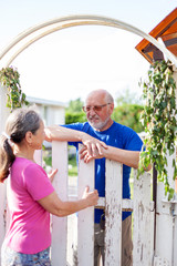 cute older men and women at gate of   country house.