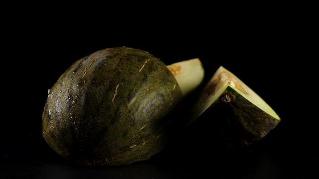 Sliced ​​fresh sweet melon fruit rotates against black background
