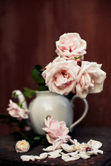  bouquet of pale pink roses in   white teapot vase.