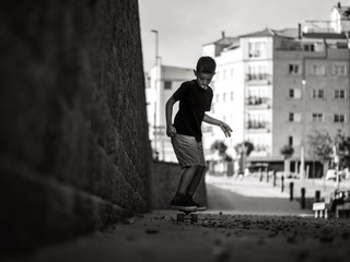 young man skate boarding on the street on a black and white photo