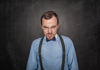 Angry business man or teacher on blackboard