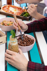 Man is having breakfast with green smoothie and chocolate cornflakes on a terrace