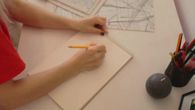 Close up girl draws a pencil on paper at home. Female fashion designer drawing sketches the dress. Fashion designer drawing and paint. Study design tutorial animator illustrator work freelance