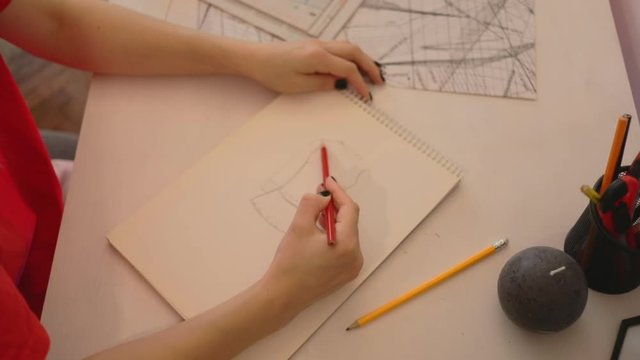 Close up girl draws a pencil on paper at home. Female fashion designer drawing sketches the dress. Fashion designer drawing and paint. Study design tutorial animator illustrator work freelance session