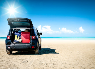 Fototapeta na wymiar Black summer car on beautiful sunny beach. Summer journey and stopover on the beach.