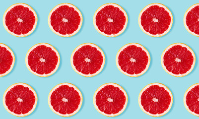 Fruit pattern from slices of grapefruit on blue background