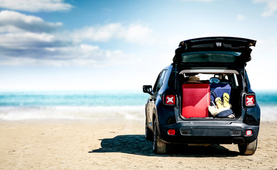 Fototapeta na wymiar Black summer car on beautiful sunny beach. Summer journey and stopover on the beach.
