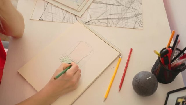 Close up girl draws a pencil on paper at home. Female fashion designer drawing sketches the dress. Fashion designer drawing and paint. Study design tutorial animator illustrator work freelance wedding