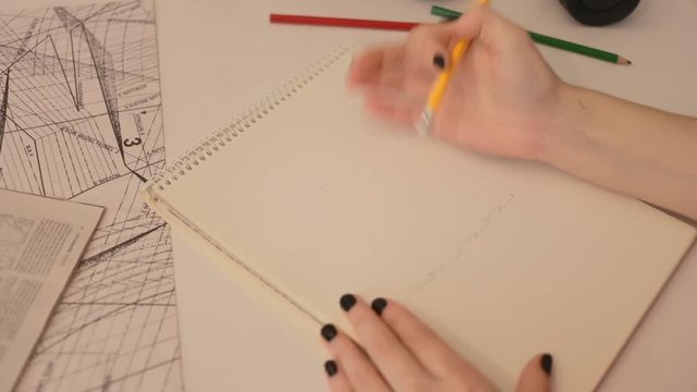 Close up woman draws a pencil on paper. Female fashion designer drawing sketches the dress. Fashion designer drawing and paint. Study design tutorial animator illustrator work freelance wedding