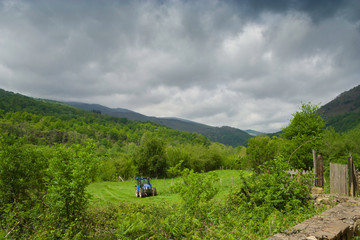 Fototapeta na wymiar Farm tractor tilling green fields,agricultural landscape