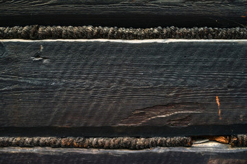 old black wooden wall of a barn - with boards and beams joined in a traditional way