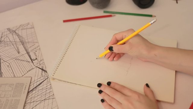 Close up girl draws a pencil on paper. Female fashion designer drawing sketches the dress. Fashion designer drawing and paint. Study design tutorial animator illustrator work freelance wedding