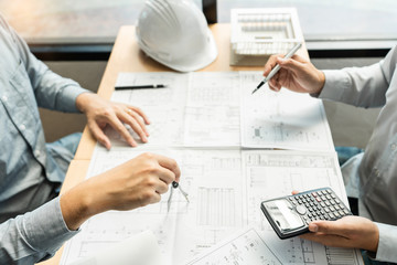 Real-estate concept, Two engineer and architect discussing blueprints data working and digital tablet on construction building project.