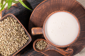 Top view hemp milk and grains in brown ceramic crockery. 
