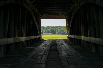 Obraz premium Looking through a covered bridge to the farm beyond, in Parke County, Indiana