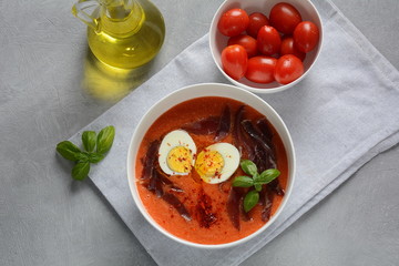 Traditional Spanish andalusian tomato cream soup Salmorejo served with egg, ham jamon in a bowl. Summer cold soup concept 