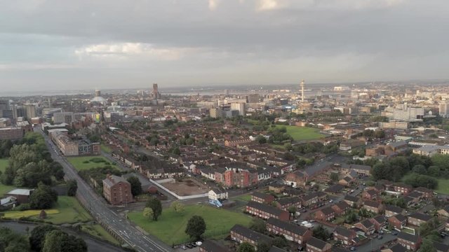 Aerial cityscape across Liverpool city buildings, cathedral, radio city tower along skyline. Ascending aerial view.