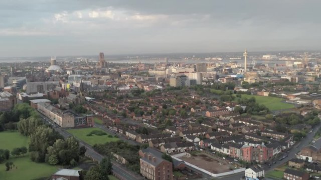 Aerial cityscape across Liverpool city buildings, cathedral, radio city tower along skyline. Dolly right.
